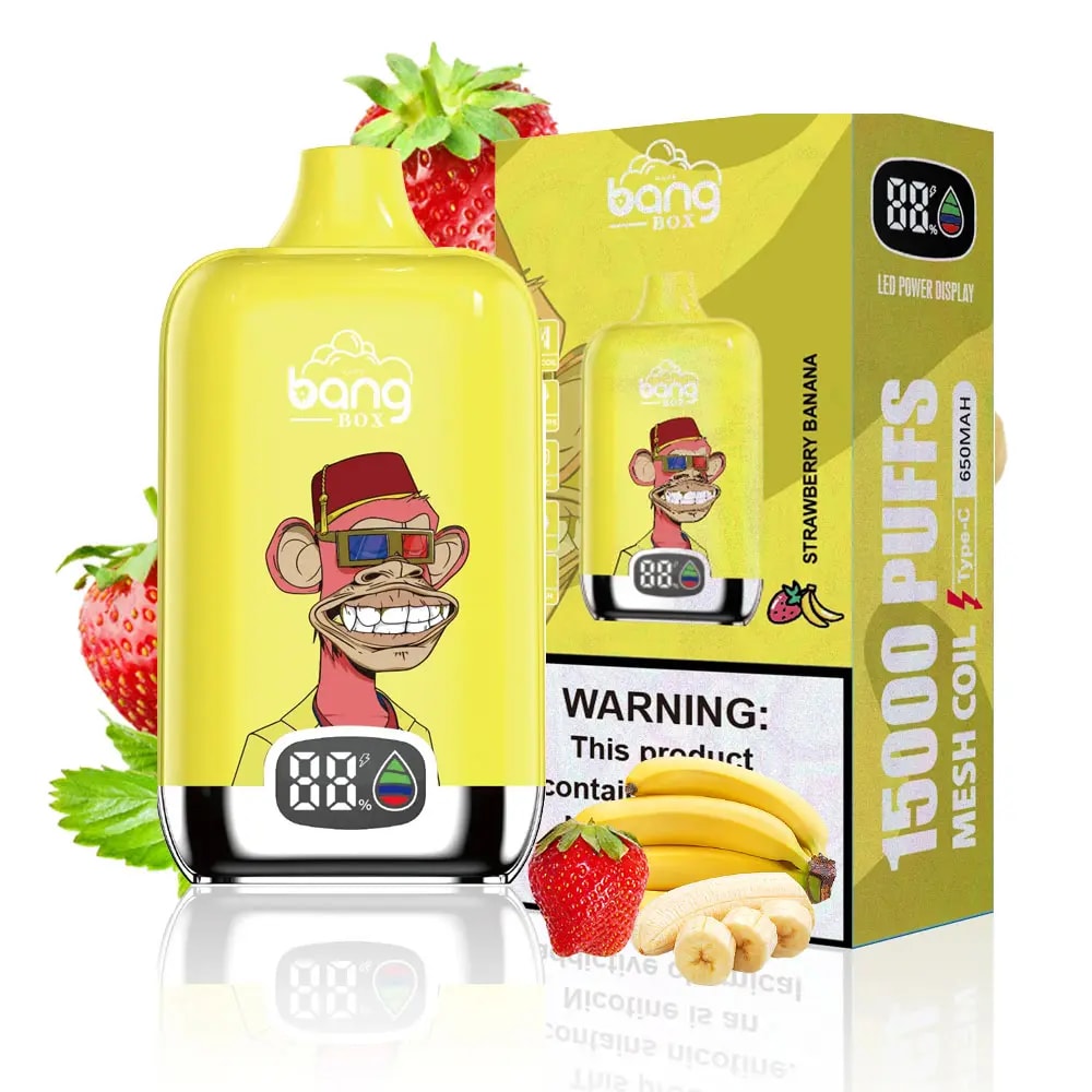 Yellow Bang Box disposable vape device with a graphic of a grinning monkey wearing 3D glasses and a red fez hat, displayed in front of its yellow box labeled '15000 puffs' and 'Strawberry Banana' flavor, surrounded by fresh strawberries and bananas.