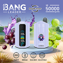 Two lavender-colored BANG LEADER vape devices with digital display and double flavor feature, placed on a round platform with splashes of black and green grapes in the background and icons indicating Type-C charging, 650mAh battery, dual mesh, and adjustable settings