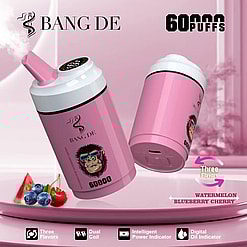 Two pink Bang De vaping devices with a stylized gorilla wearing sunglasses on the label, emitting vapor, showcased with watermelon, blueberries, and cherry to indicate flavors, highlighting 60,000 puffs, three flavors, dual coil, intelligent power indicator, and digital oil indicator features against a pink background.