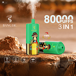 Two green and gold disposable vape devices branded BANG DE with a cartoon monkey design, one standing upright emitting vapor, the other lying down on a textured rock surface, surrounded by product information texts including 8000 puffs, 3 in 1 flavor, 650mAh battery, 20ml volume, and Type-C charging.