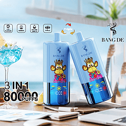 Two blue BANG DE vape devices with a cartoon monkey wearing a crown and pink jacket, displayed on a table with a beach background, alongside a blue cocktail glass and text highlighting 3 in 1 flavor, 650mAh battery, 20ml volume, Type-C charging, and 80,000 puffs.
