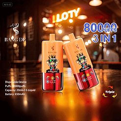 Two orange and red disposable vape devices with a cartoon monkey wearing a crown and sunglasses, displayed on a wooden surface in a warmly lit bar or cafe setting, advertised as BANG DE brand with 80,000 puffs, 3-in-1 flavor capacity, and 650mAh battery.