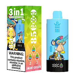 Blue Bang King vape device with pineapple ice flavor featuring a monkey character wearing a colorful mohawk and suit, shown next to its green and yellow gradient packaging with warnings, 3 adjustable flavors, and smart screen indicator.