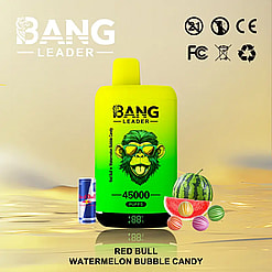 Bright green and yellow Bang Leader vaping device with a monkey wearing sunglasses on the front, labeled Red Bull Watermelon Bubble Candy flavor with 45000 puffs, next to a can of Red Bull and various watermelons, including a sliced watermelon and colorful striped balls, on a reflective surface.