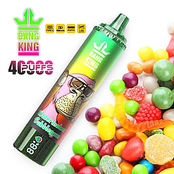 Green and multicolored disposable vape pen labeled Bang King Watermelon Bubblegum placed near a pile of colorful assorted candies and gummies