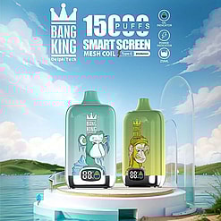Two Bang King vape devices with cartoon ape designs, one blue and one green, displayed on a white round pedestal by a lake with a partly cloudy sky in the background