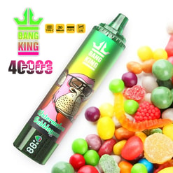 Green and multicolored disposable vape pen labeled Bang King Watermelon Bubblegum placed near a pile of colorful assorted candies and gummies